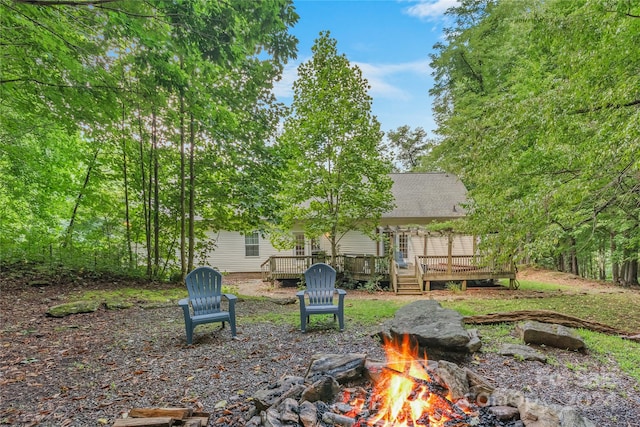 view of yard with a deck and an outdoor fire pit