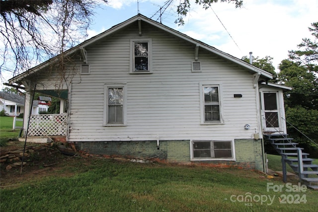 rear view of property featuring a yard