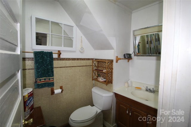 bathroom with vanity, toilet, ornamental molding, and tile walls