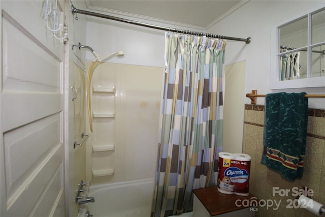 bathroom with ornamental molding and shower / bath combination with curtain