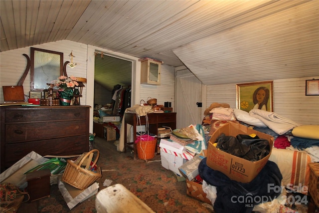 bedroom featuring a closet, wood ceiling, wooden walls, and vaulted ceiling