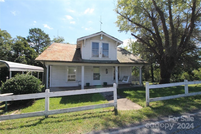 view of front of home with covered porch, a front lawn, and a carport