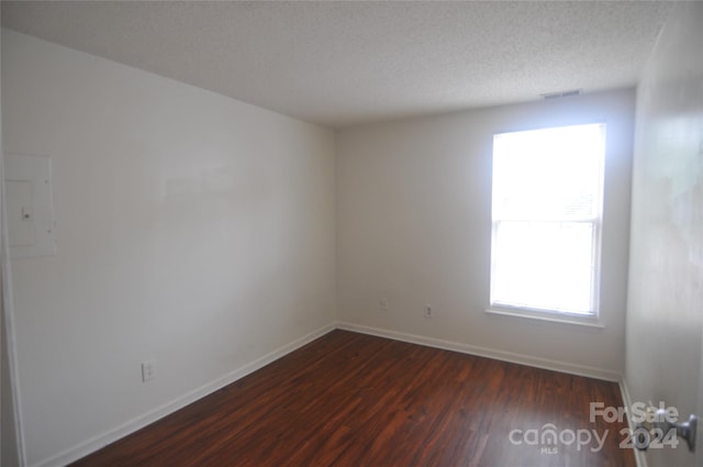 spare room with hardwood / wood-style flooring and a textured ceiling