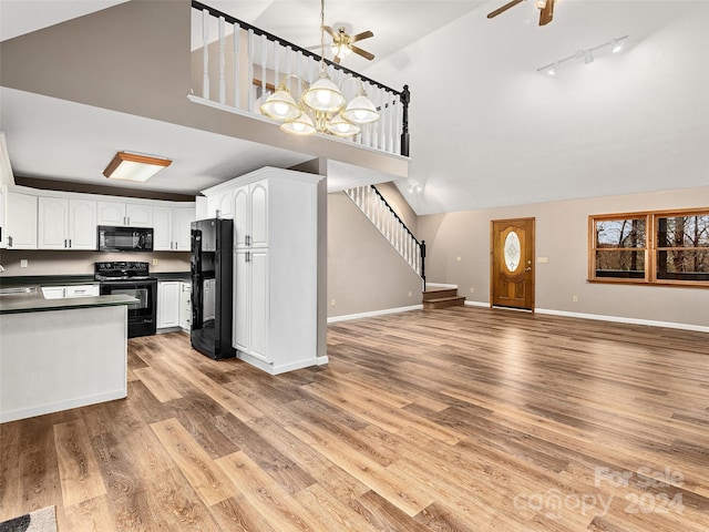 kitchen featuring track lighting, white cabinetry, light wood-type flooring, and black appliances