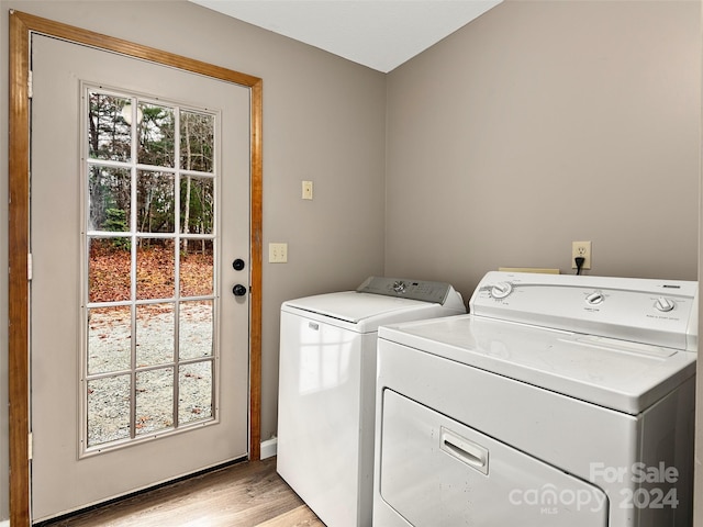 clothes washing area with light hardwood / wood-style flooring and washer and dryer