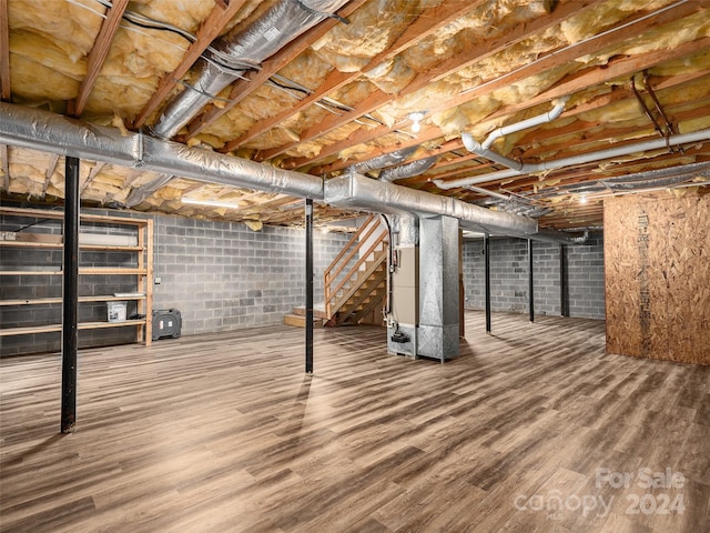 basement featuring heating unit and hardwood / wood-style floors