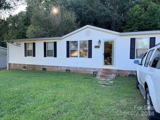 manufactured / mobile home featuring a front lawn