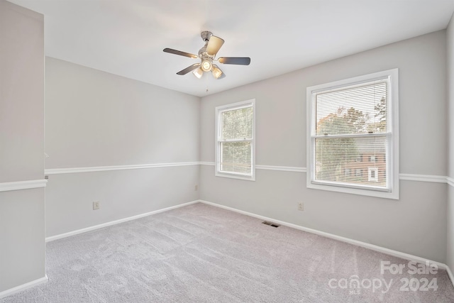 spare room featuring light carpet and ceiling fan