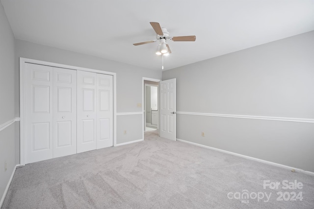 unfurnished bedroom with light carpet, ceiling fan, and a closet