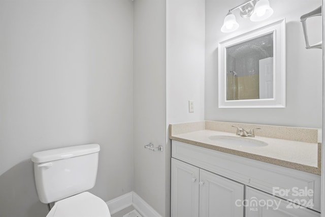 bathroom featuring walk in shower, vanity, and toilet