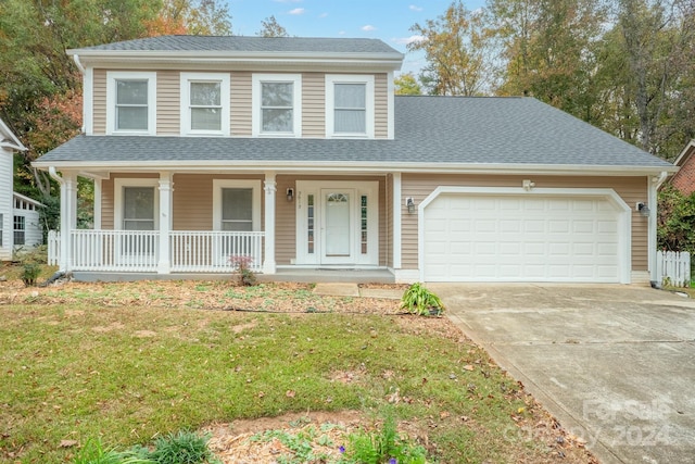 view of front of home with a porch, a front lawn, and a garage