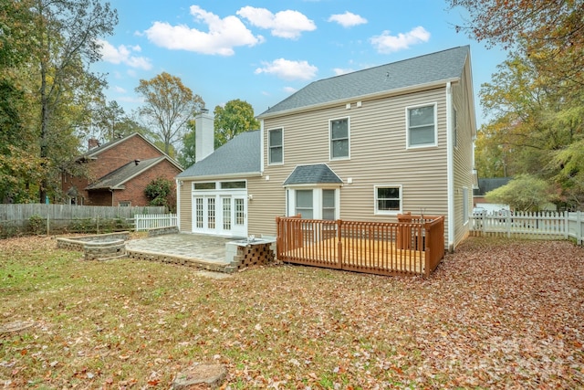 back of property with french doors, a yard, and a deck