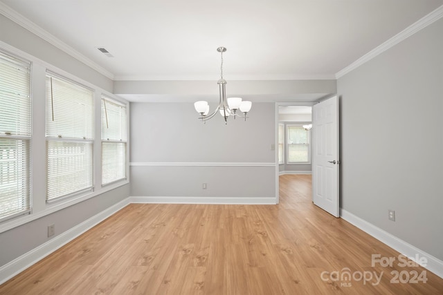 unfurnished dining area with a chandelier, crown molding, and light hardwood / wood-style flooring