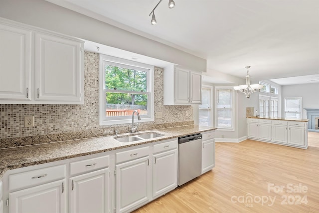 kitchen with pendant lighting, decorative backsplash, sink, white cabinets, and stainless steel dishwasher