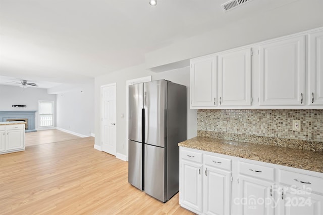 kitchen with white cabinets, stainless steel refrigerator, and light wood-type flooring