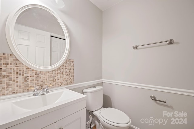 bathroom with toilet, backsplash, and vanity