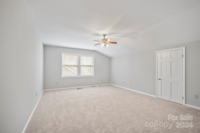 unfurnished room with lofted ceiling, ceiling fan, and carpet floors