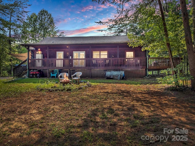 back house at dusk featuring a deck