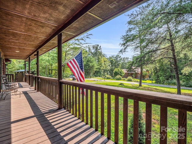 wooden terrace with a porch and a yard