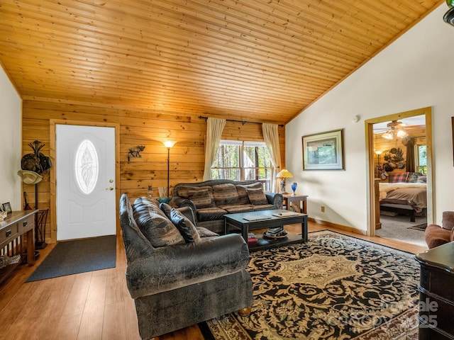 living room featuring ceiling fan, wooden ceiling, high vaulted ceiling, wood walls, and hardwood / wood-style floors