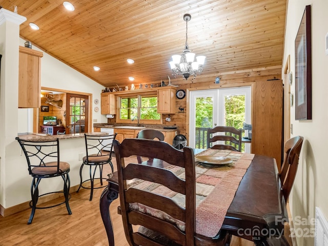 dining room with lofted ceiling, wooden ceiling, an inviting chandelier, sink, and light hardwood / wood-style flooring