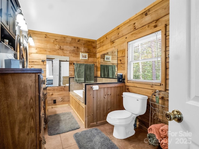 bathroom featuring tile patterned floors, wooden walls, a bath, and toilet