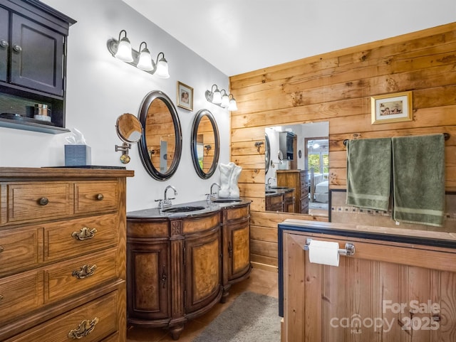 bathroom featuring tile patterned floors, wood walls, and vanity