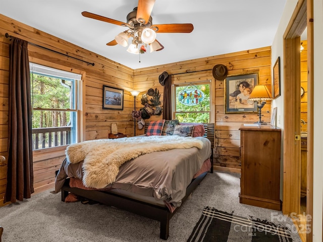 bedroom featuring carpet, ceiling fan, and wood walls