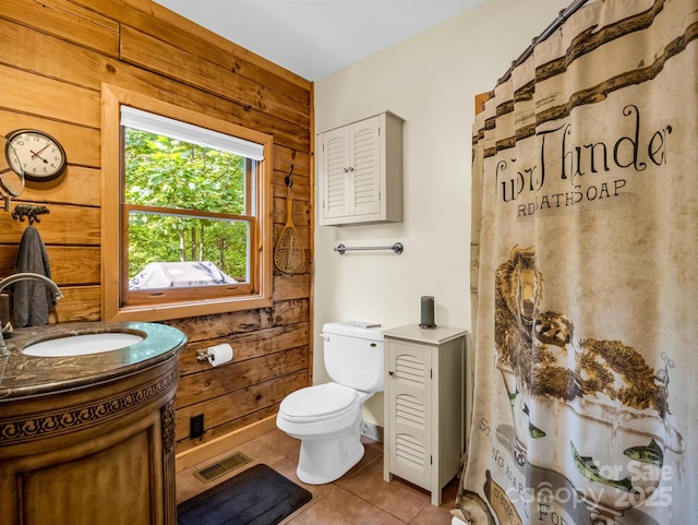 bathroom featuring curtained shower, tile patterned flooring, toilet, wooden walls, and vanity