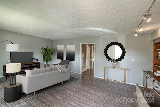 living room featuring hardwood / wood-style floors, a textured ceiling, and track lighting