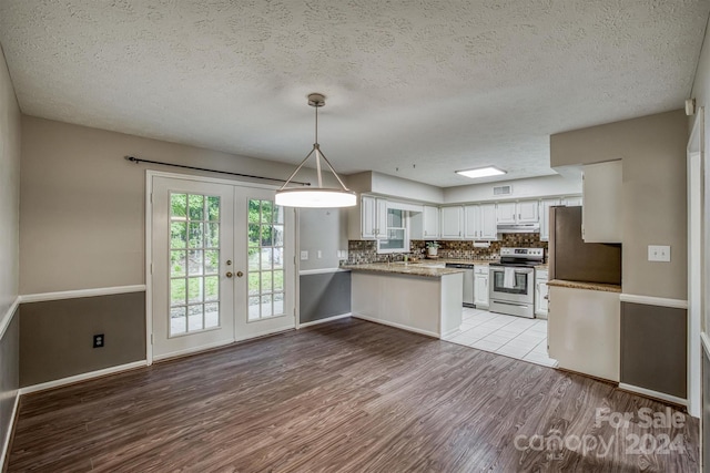 kitchen with a textured ceiling, appliances with stainless steel finishes, light hardwood / wood-style floors, white cabinetry, and kitchen peninsula