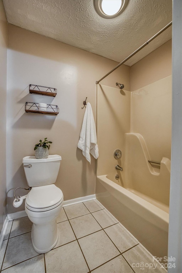 bathroom featuring a textured ceiling, shower / bathtub combination, toilet, and tile patterned floors