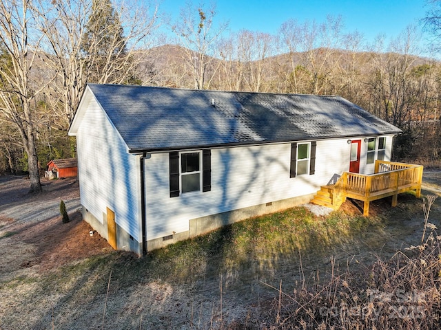 rear view of house featuring a deck with mountain view