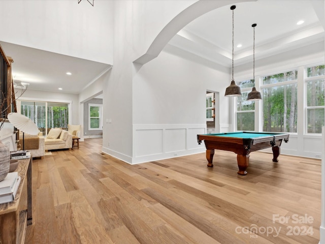 playroom with a towering ceiling, billiards, ornamental molding, and light hardwood / wood-style flooring