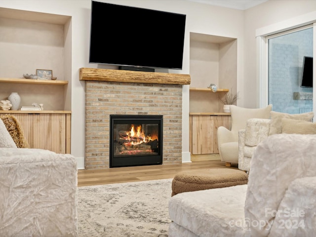 living room featuring hardwood / wood-style flooring and a brick fireplace