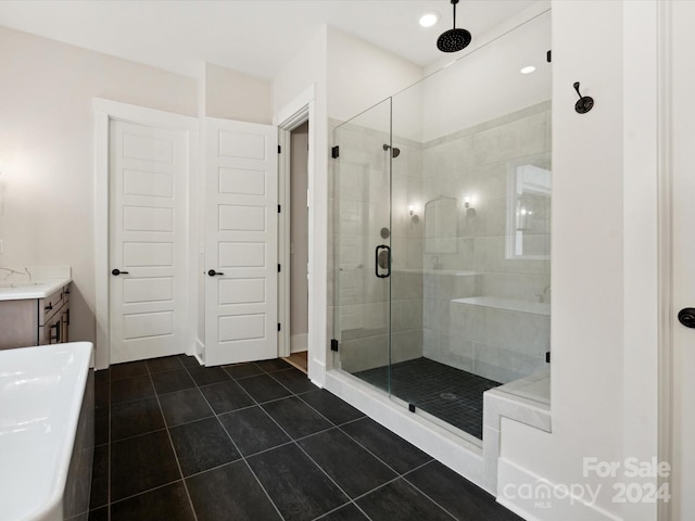 bathroom featuring vanity, a shower with shower door, and tile patterned floors