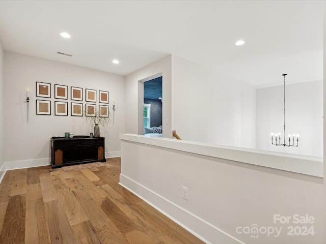 hall featuring a notable chandelier and light wood-type flooring