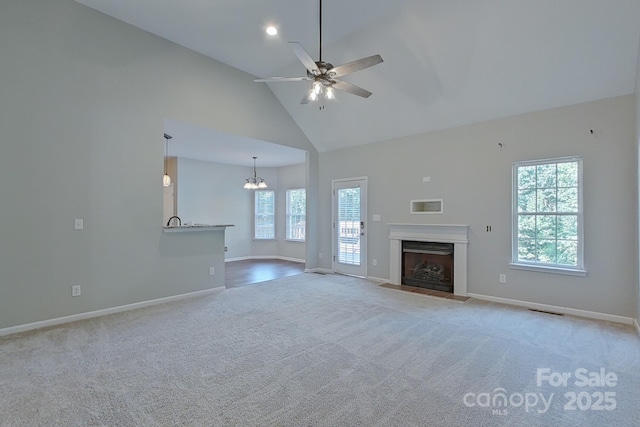 unfurnished living room featuring ceiling fan, light colored carpet, and high vaulted ceiling