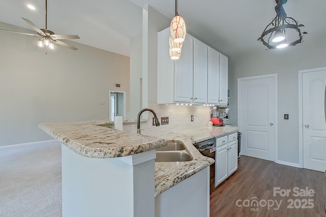 kitchen featuring decorative light fixtures, sink, white cabinets, and kitchen peninsula