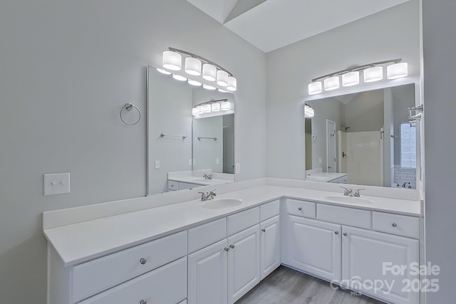 bathroom with lofted ceiling, vanity, a shower, and hardwood / wood-style flooring