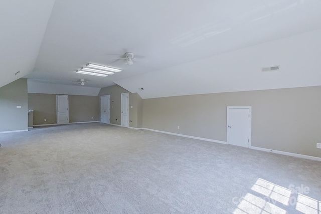 carpeted spare room with ceiling fan and lofted ceiling