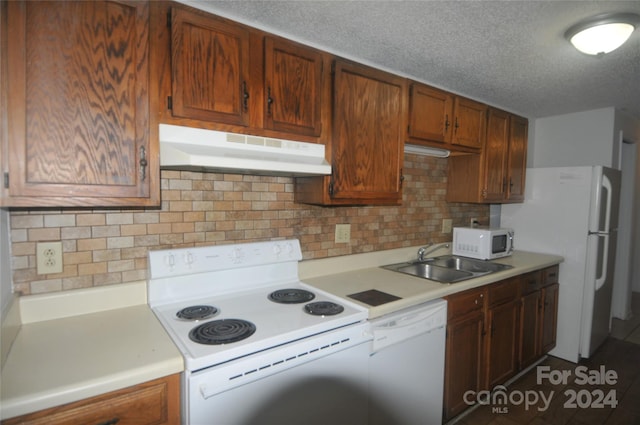 kitchen featuring sink, tile patterned floors, white appliances, tasteful backsplash, and a textured ceiling