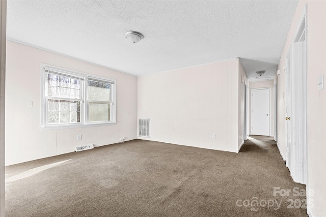 carpeted spare room featuring a textured ceiling