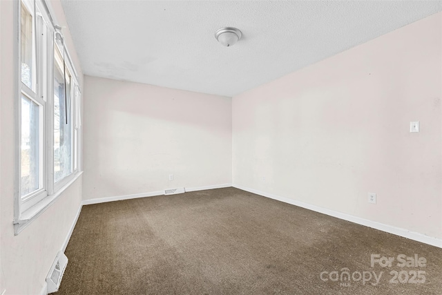 carpeted spare room featuring a textured ceiling