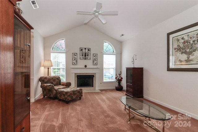 living area with ceiling fan, vaulted ceiling, and light carpet