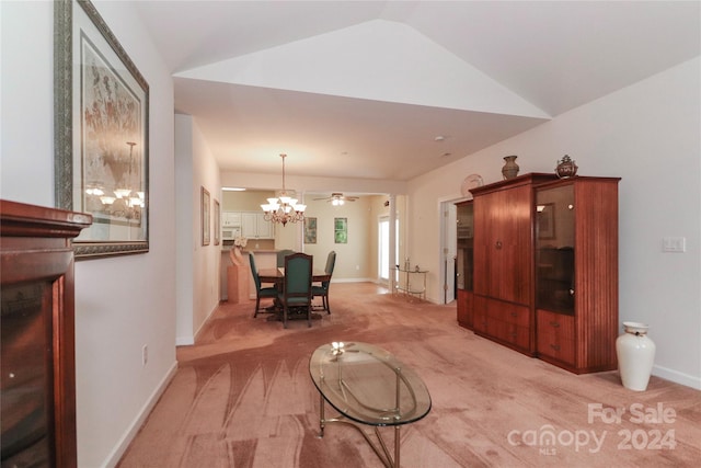 carpeted living room featuring lofted ceiling and ceiling fan with notable chandelier