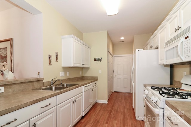 kitchen featuring sink, white cabinets, light hardwood / wood-style floors, and white appliances