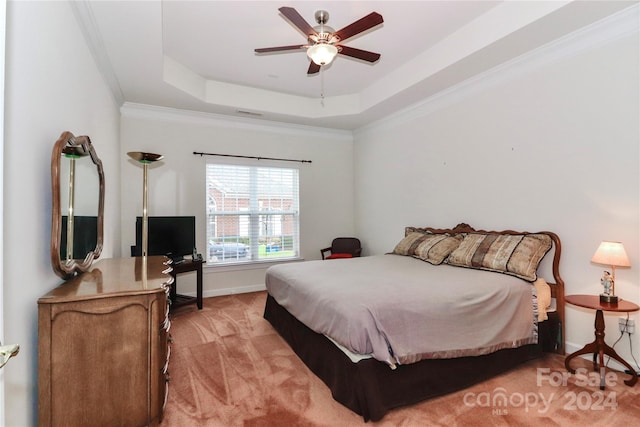 bedroom featuring a tray ceiling, ceiling fan, ornamental molding, and light colored carpet