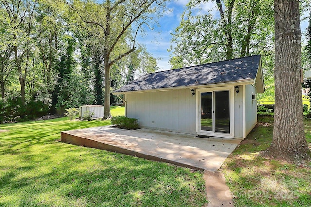 rear view of house featuring a lawn, a storage shed, and a patio