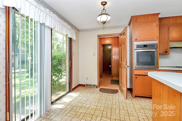 kitchen with stainless steel oven and pendant lighting